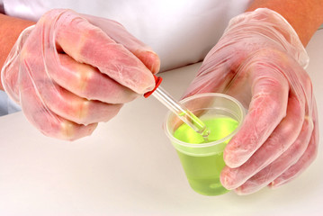 Pipette neben Messbecher mit Flüssigkeit