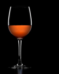 A glass of rose wine, isolated on a black background.
