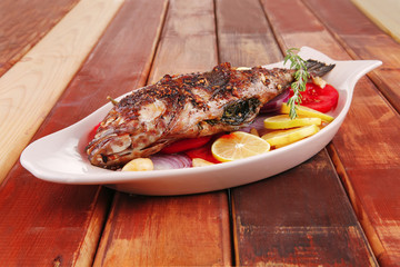 whole fried bass on wooden table