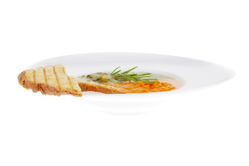 vegetable soup served with toasts on white dish