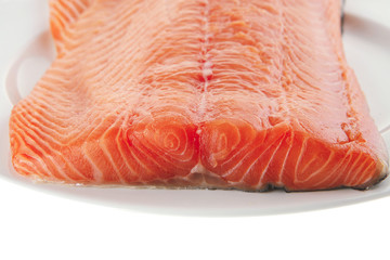big salmon fillet on white plate