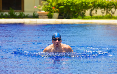 The young sports swimmer in pool