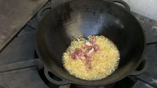 Adding pieces of meat to Frying onion in Wok