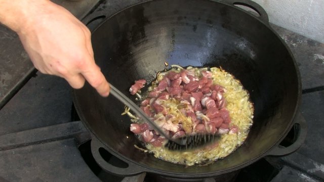 Stirring pieces of meat and Frying onion in Wok
