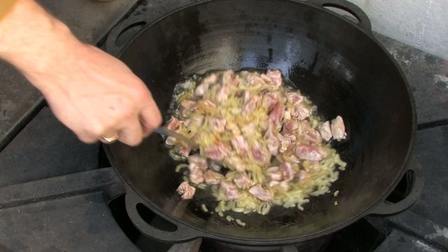 Roasting pieces of meat and onion in Wok