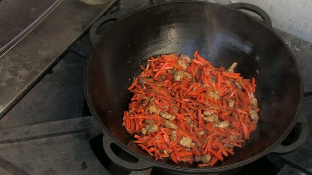 Adding spice to Pilaf ingredients in Wok, Closeup