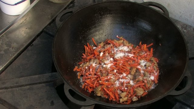 Adding Salt to Pilaf ingredients in Wok, Closeup