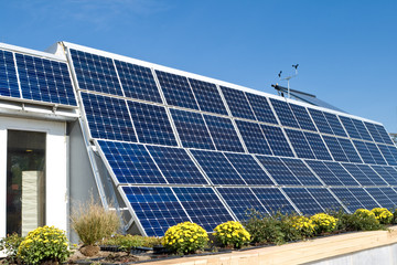 Modern Home with Row Photovoltaic PV Solar Panels and Anemometer