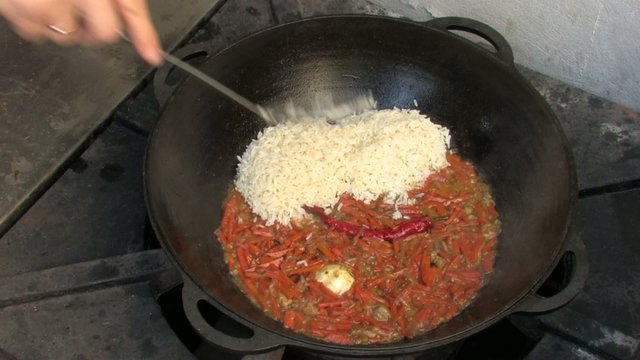 Adding Rice to Pilaf ingredients in Wok
