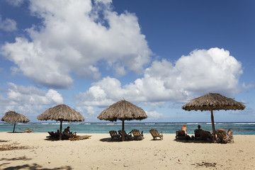 Transats et parasol sur une plage aux Caraïbes