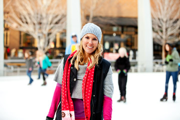 A woman smiling at an outdoor ice rink
