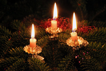 Weihnachten: drei brennende Kerzen am Christbaum