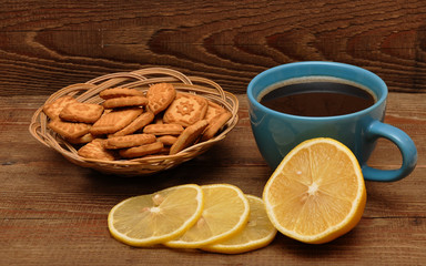 cup of tea with lemon and cookies in basket