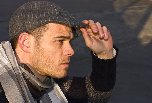 young man holding his hat.