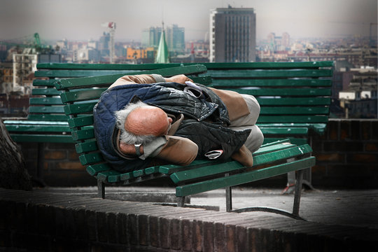 homeless che dorme su una panchina