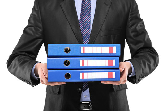 A close up of a businessman holding three blue folders