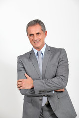 Fototapeta premium Smiling businessman standing on white background