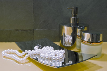 collana di perle sul piatto di acciaio sul piano del bagno