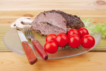 beef on transparent plate over wood