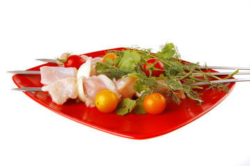 raw kebabs on red plate