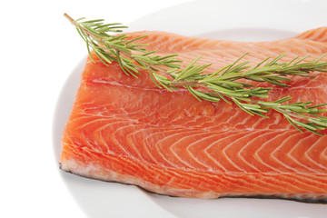 fresh uncooked salmon fillet on plate with rosemary