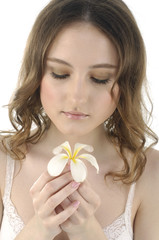 Close up smiling woman holding frangipani flower