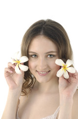 Obraz na płótnie Canvas close up young woman holding frangipani flower