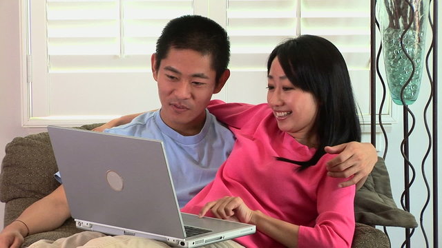 Young Asian couple working on laptop