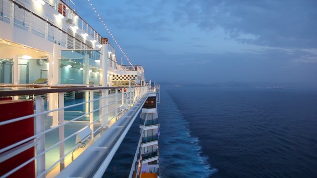 boy walks on cruise ship in night sea