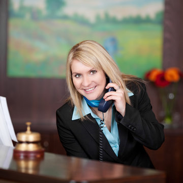 lächelnde hotelangestellte am telefon