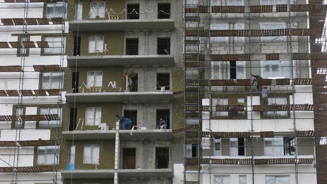 Under construction house: workers on each floor.