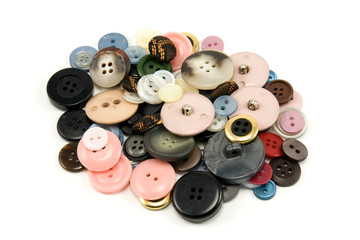 pile of various sewing buttons on white background
