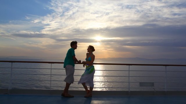 couple stands on deck of cruise ship and talks