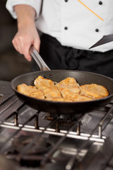 koch brät schnitzel in der pfanne