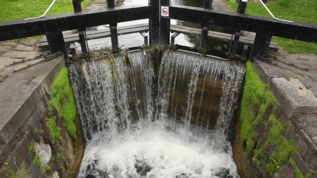 stream run through sluice made of wood and falls into canal