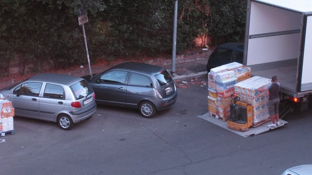 men load some cargo on truck with pallet jack  in Rome, Italy.