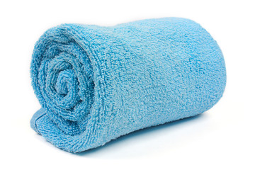 rolled up blue beach towel on white background