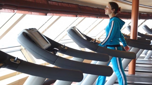 back view on woman running in gym