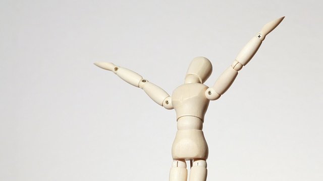 rotating wooden figure of man with raised hands