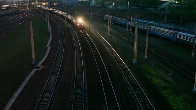 suburban electric train moving on night railway near station