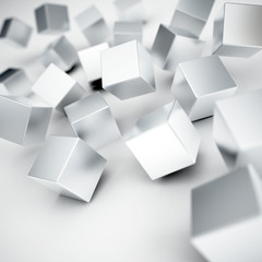 Falling and hitting gray metallic cubes on a white