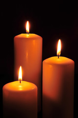 Fototapeta na wymiar trzy świece w ciemności