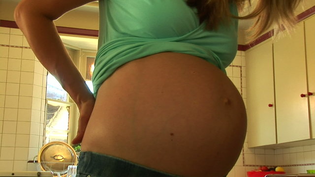 Portrait of pregnant woman showing belly