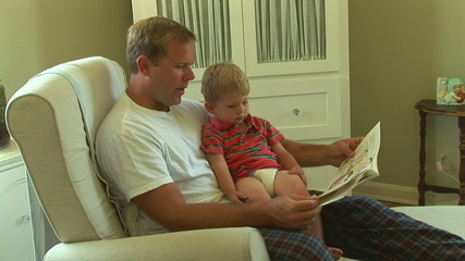 Father and toddler son reading book together - Powered by Adobe