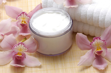 Obraz na płótnie Canvas Spa essentials (cream, white towel and pink orchids)