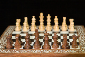 closeup of chess pieces on a wooden chess board