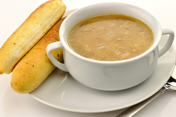 French Onion Soup in a white bowl with bread sticks