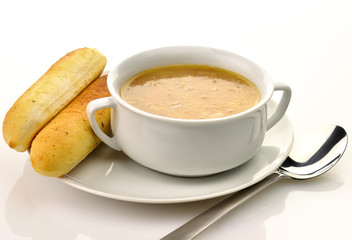 French Onion Soup in a white bowl with bread sticks