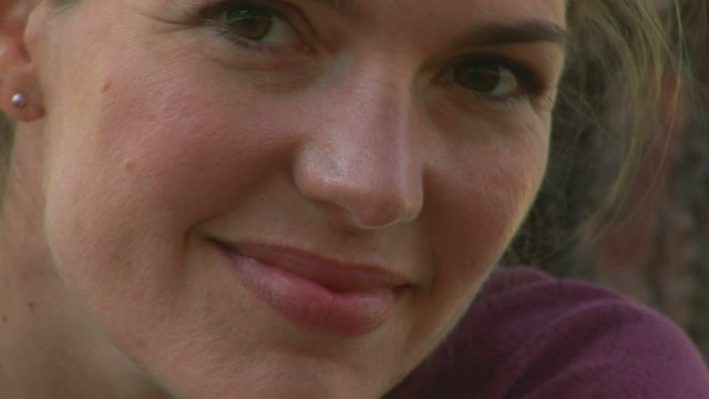 Close-up portrait of young woman outdoors smiling