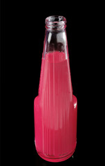 red cocktail in a glass bottle on a black background